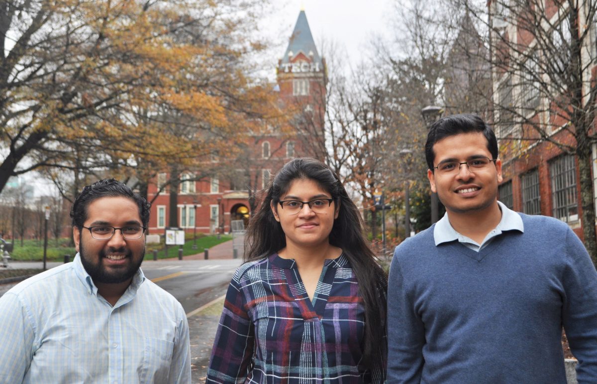 Team Optibag, Sreenath Raparti, Aarohi Shah, and Mohit Gupta standing in front of Tech Tower. 