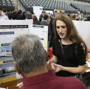 AE senior Angelina Walters explains 24-Hour Buzz, her team's entry, to a judge from Capstone Design sponsor Coke.