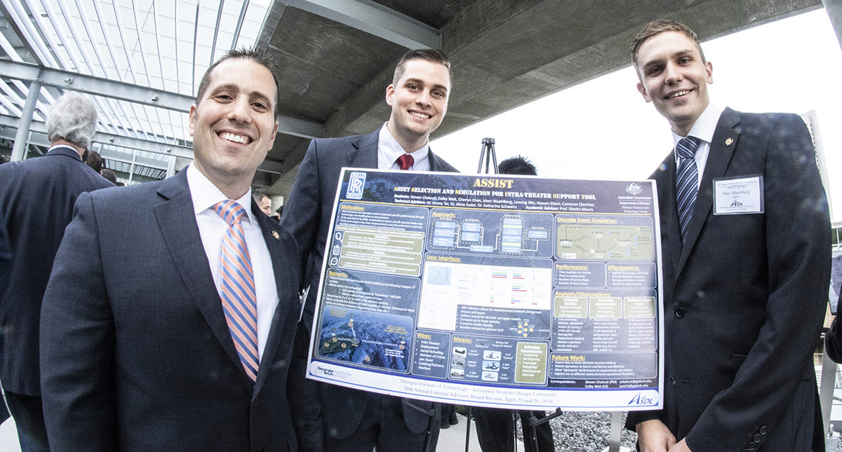 Steven Chetcuti,and two other grad students who worked on the ASSIST project stand in front of poster