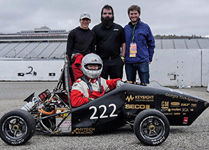 Four members of the HyTech team with their vehicle