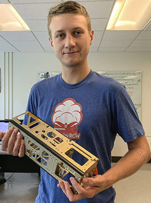 grad student Jacob Payne holding a 3U cubesat