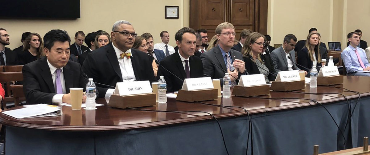 JP Clarke and other experts at a table in Congress waiting to testify