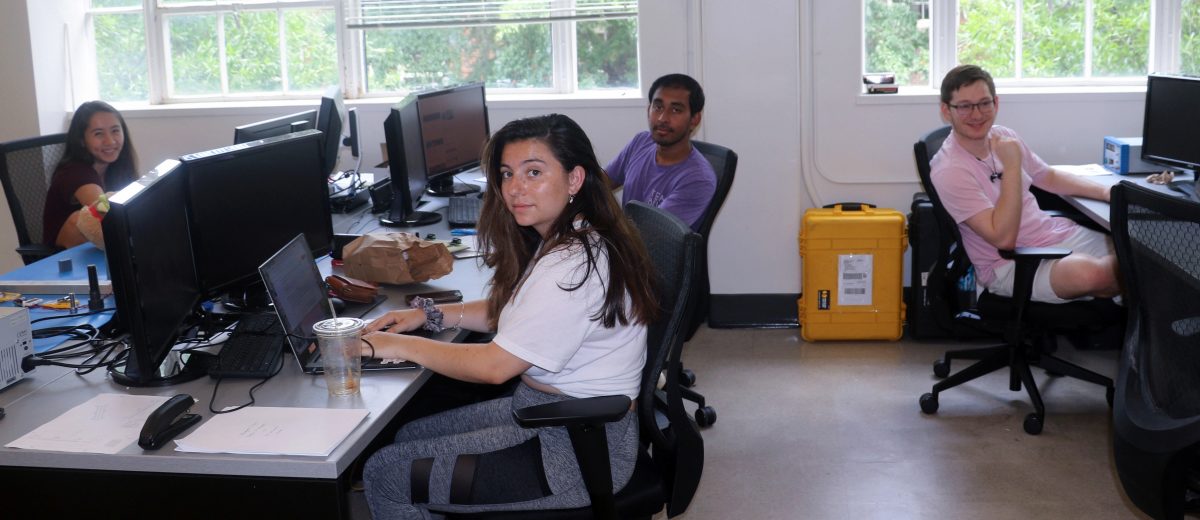 Five grad students from Prof. LIghtsey's lab working at their computers