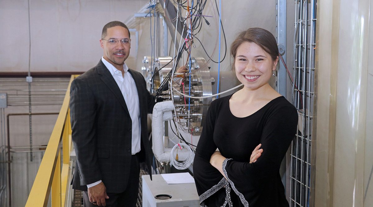 Prof. Mitchell Walker standing in front of the HPEPL vacuum chamber with Abigail McClain