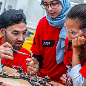 three engineering students working together on a drone 