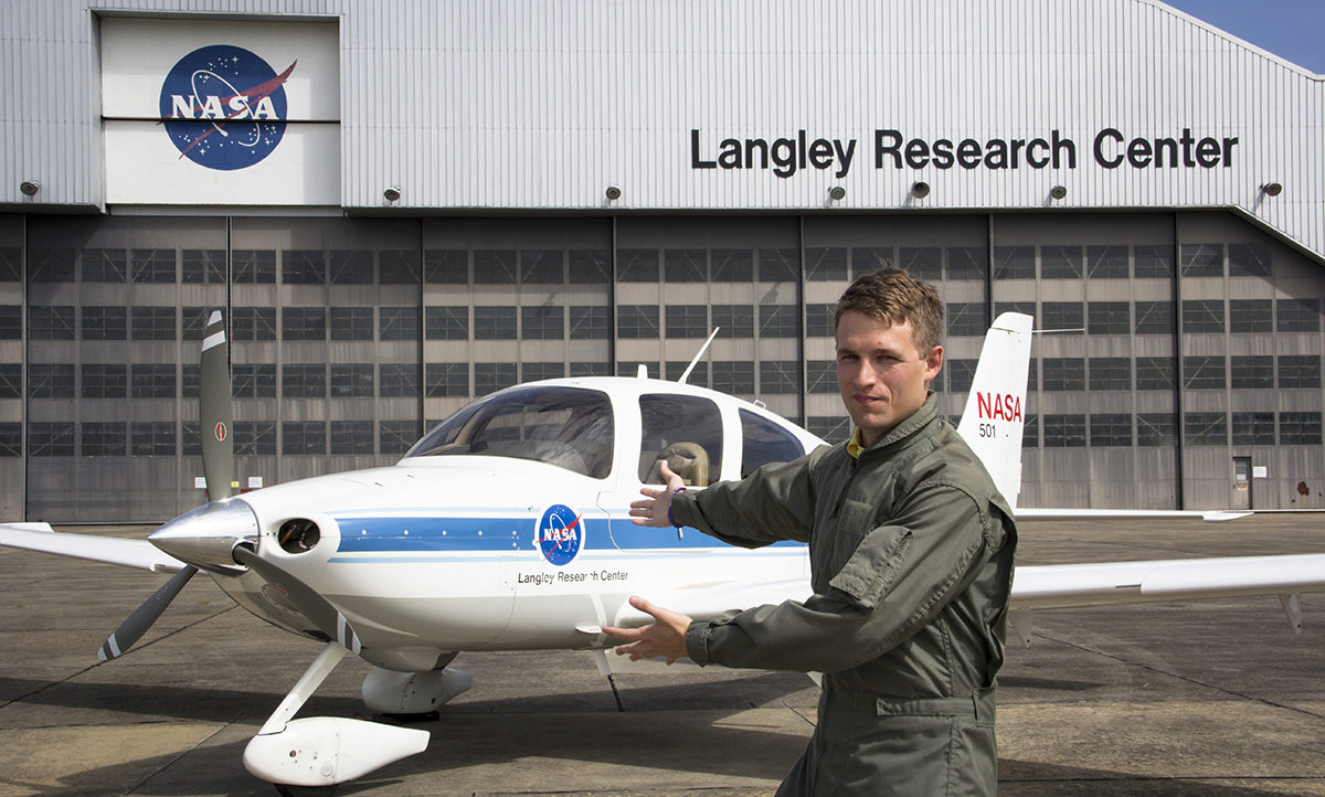 Kenneth Smith in front of the Langley Researach Center, pointing dramatically to an airplane he's been working on