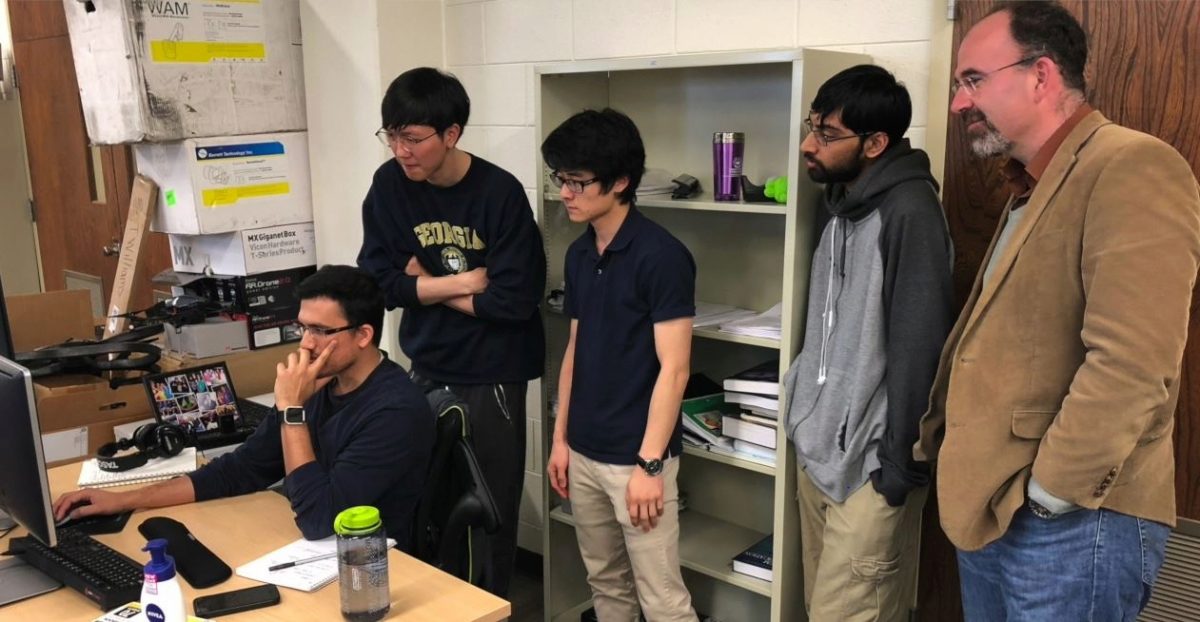 Theodorou, Patel, Oshin, Gandi  checking out some calculations on a computer screen