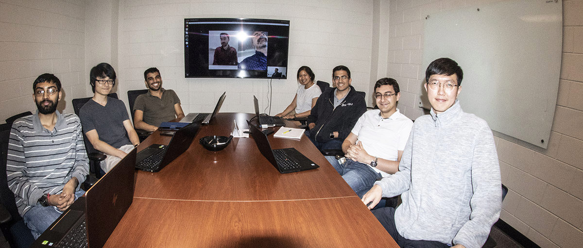 Seven of the 10-member Icarus Team sitting at a conference table