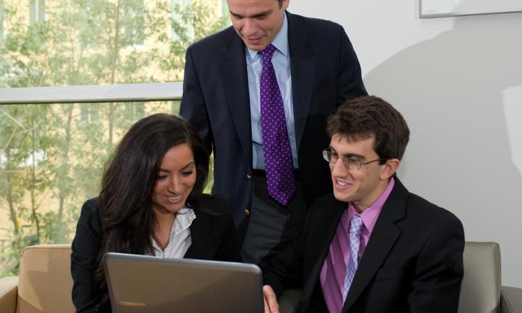 3 people in front of laptop