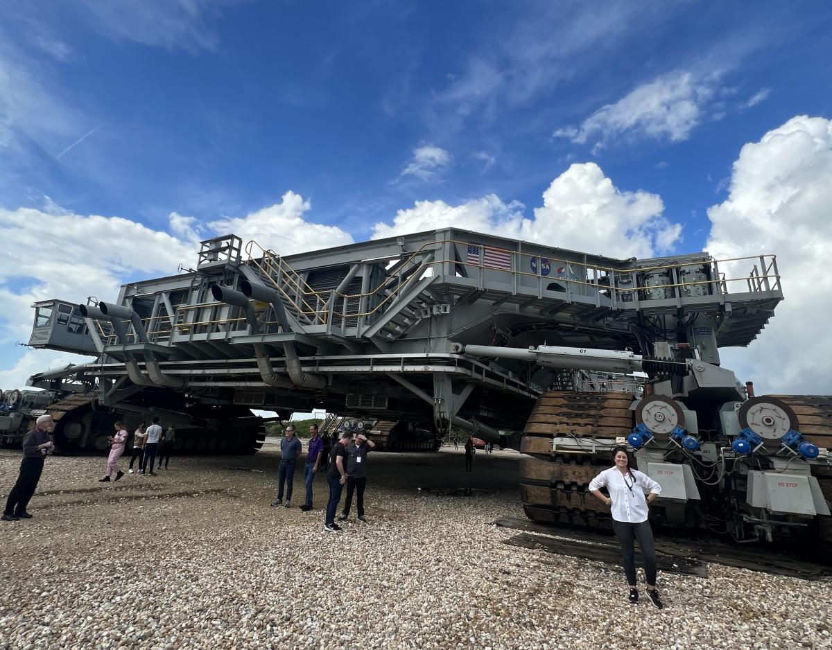 Kelsey stands in front of the crawler that transported Artemis I from the VAB to the launch pad