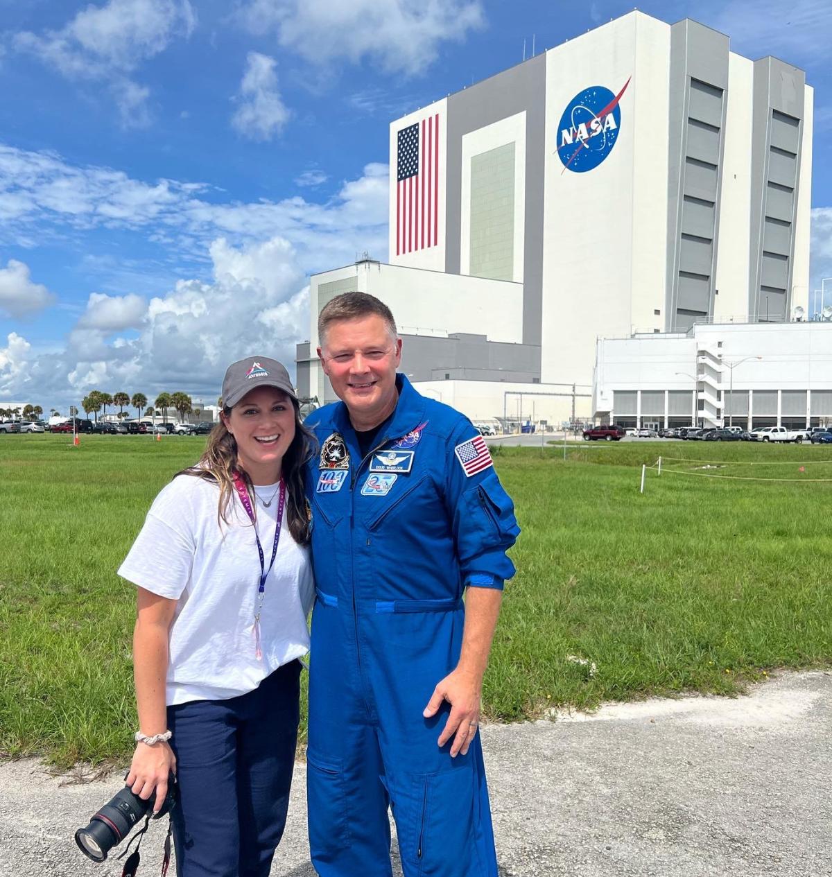 Kelsey Gulledge and Doug Wheelock (MSAE 1992) stand outside the Vehicle Assembly Building