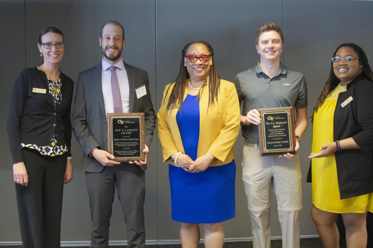 Alexander Lomis and Joe Laboon hold their co-oping award plaques 