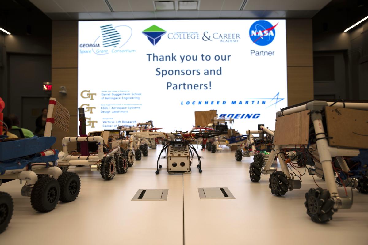 a table of mars rovers and drones built by high school students. 