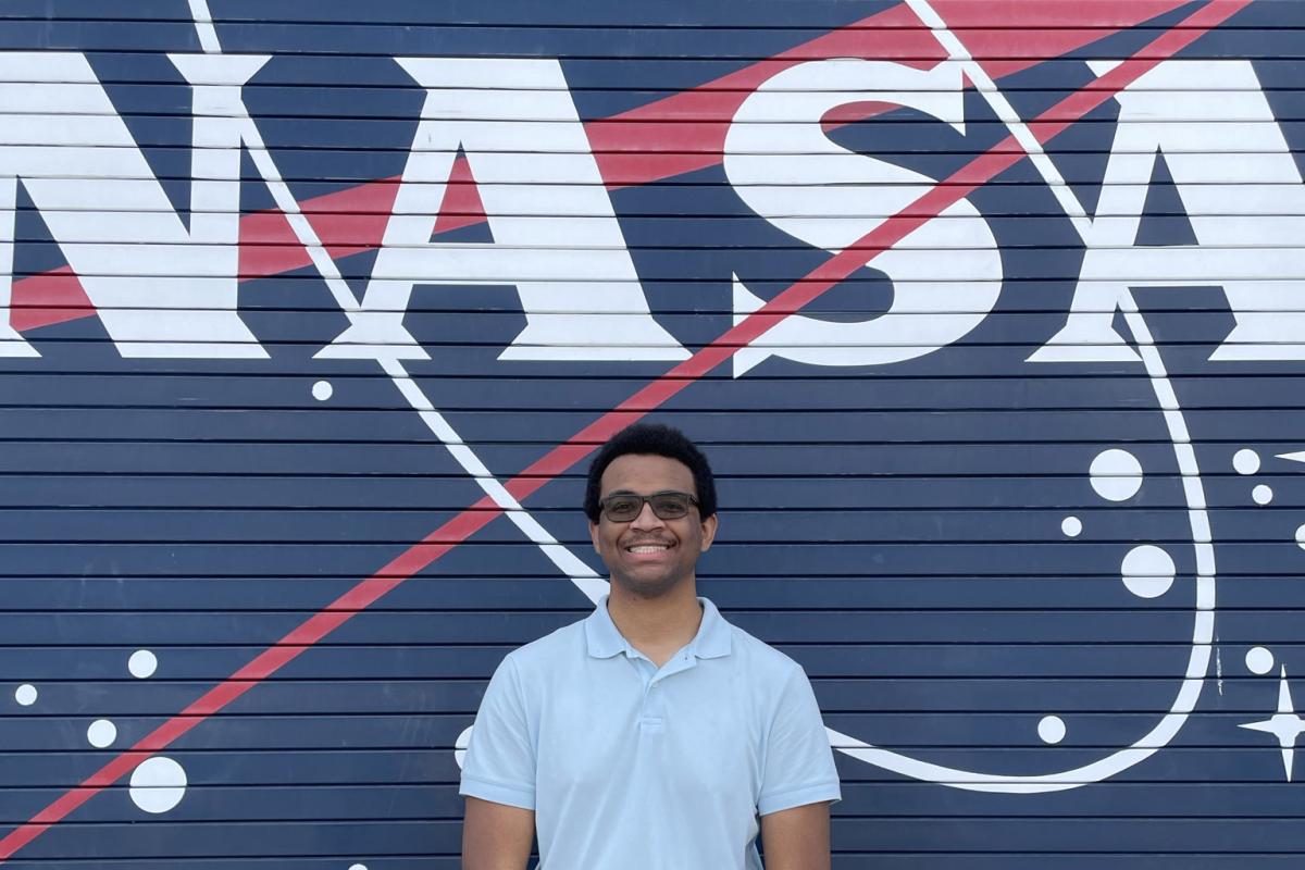 AE student Cameron Eure, proudly poses next to the iconic NASA logo during his summer internship at NASA