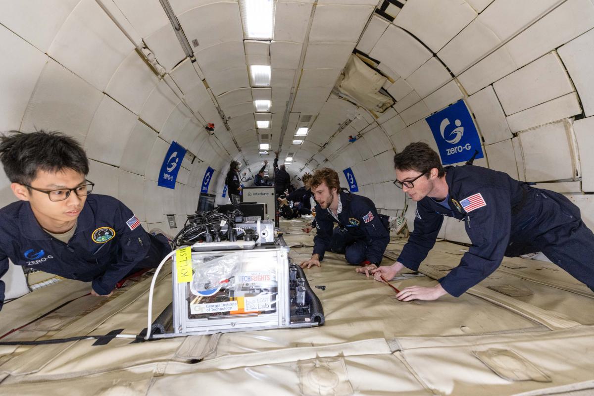 Chen (left) closely monitors the experiments during flight. 