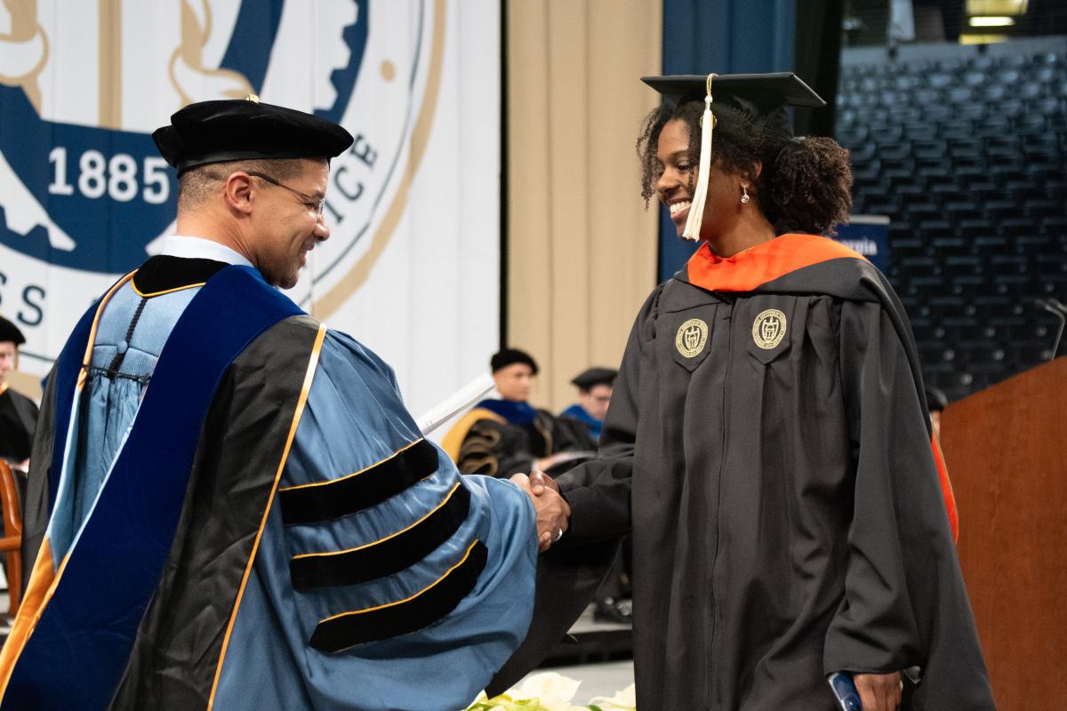 Professor Mitchell Walker 2024 at Graduation shaking hands